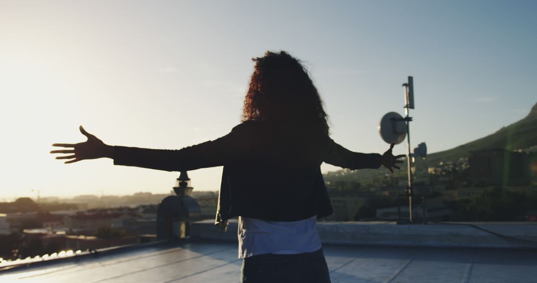 Woman Enjoying Sunset on Rooftop with Open Arms - Free Images, Stock Photos and Pictures on Pikwizard.com