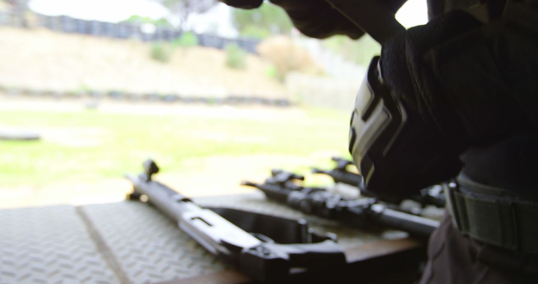 Military soldier handling equipment with rifles on display