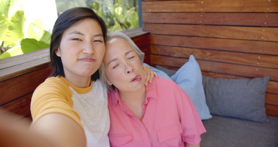 Happy Asian Family Enjoying Quality Time Taking Selfie on Patio Couch