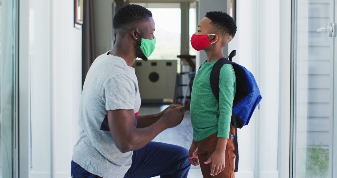Father Helping Son Wear Face Mask Before School