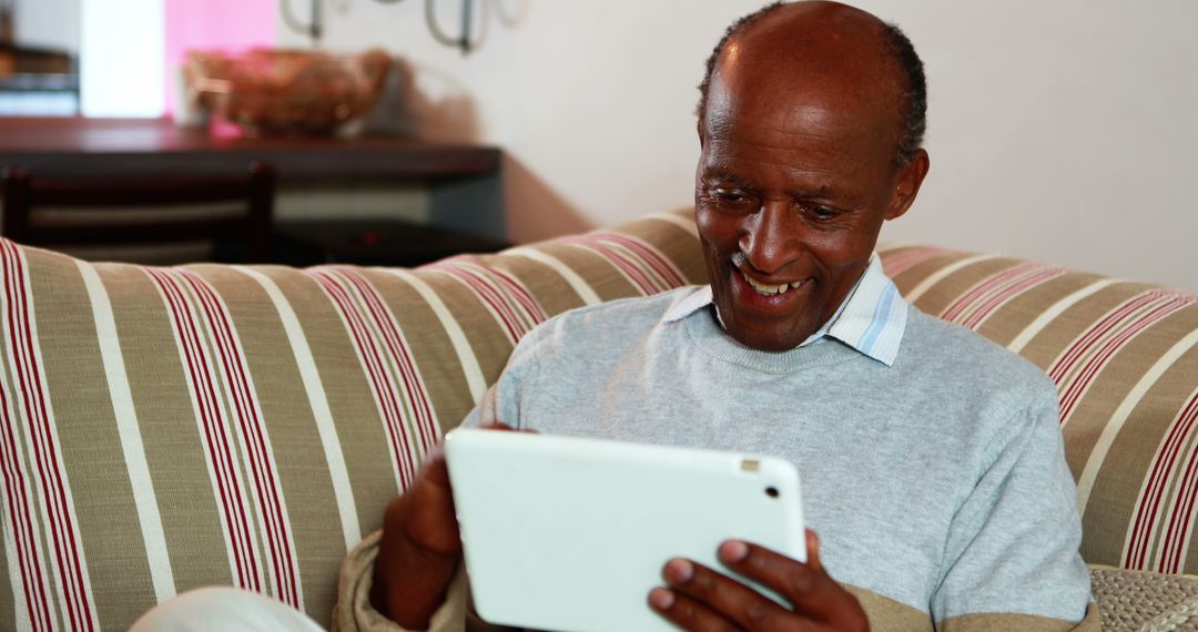 Senior Man Using Digital Tablet on Sofa - Free Images, Stock Photos and Pictures on Pikwizard.com