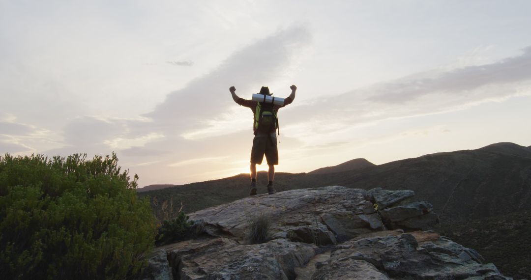 Adventurer Celebrating Success on Mountain Peak at Sunset - Free Images, Stock Photos and Pictures on Pikwizard.com