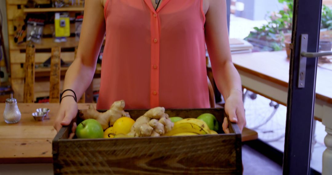 Person holding wooden crate with fresh fruits and vegetables in kitchen - Free Images, Stock Photos and Pictures on Pikwizard.com