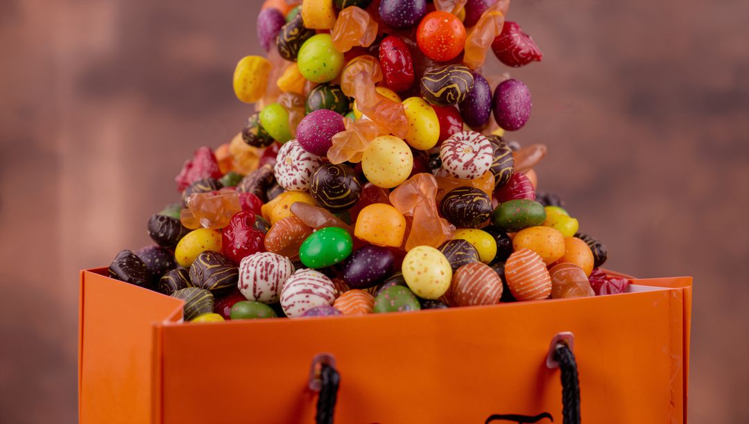Overflowing Orange Bag Filled with Colorful Candies