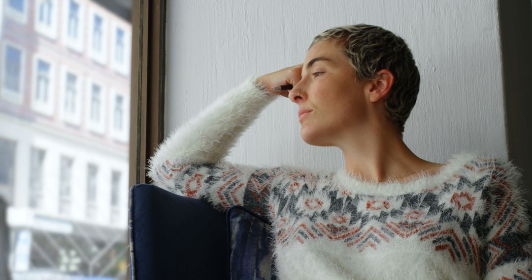 Thoughtful Woman Relaxing by Window in Cozy Sweater - Free Images, Stock Photos and Pictures on Pikwizard.com