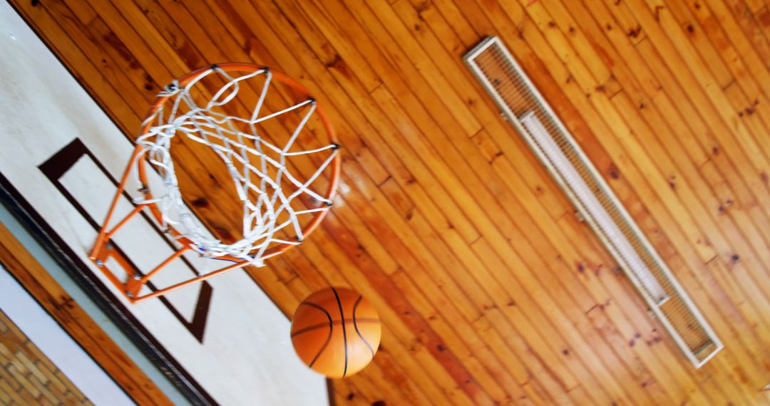 Basketball Near Hoop in Indoor Gymnasium Capturing Game Moment