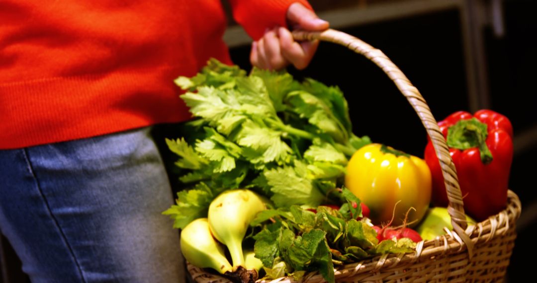 Person carrying basket of fresh vegetables including bell peppers and celery - Free Images, Stock Photos and Pictures on Pikwizard.com