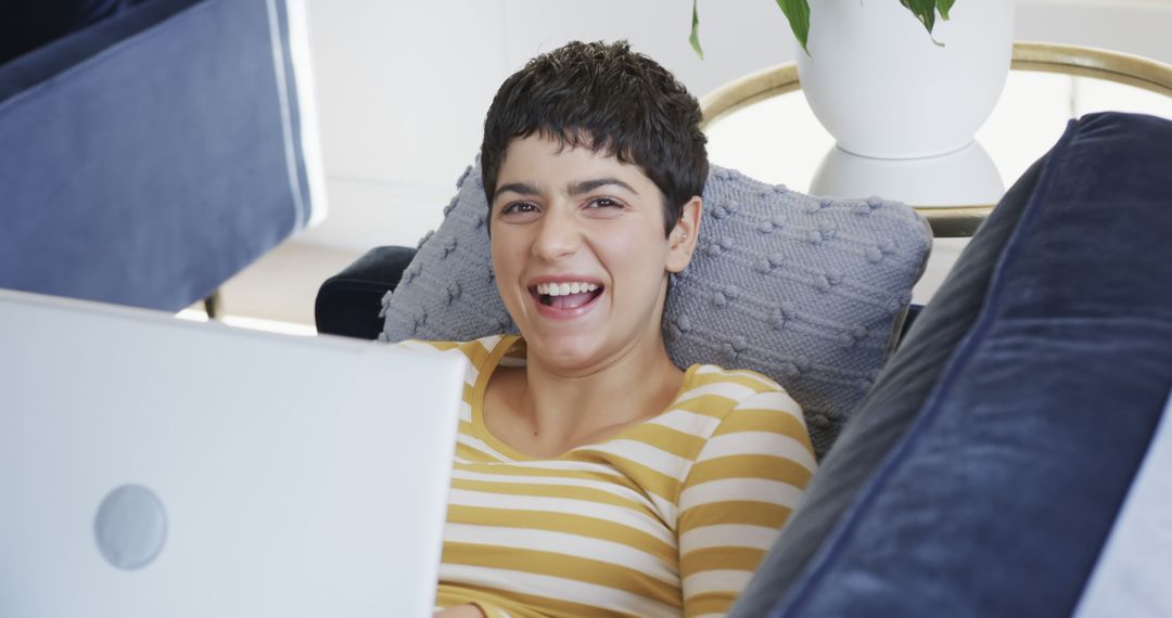 Young Woman Laughing While Using Laptop at Home - Free Images, Stock Photos and Pictures on Pikwizard.com