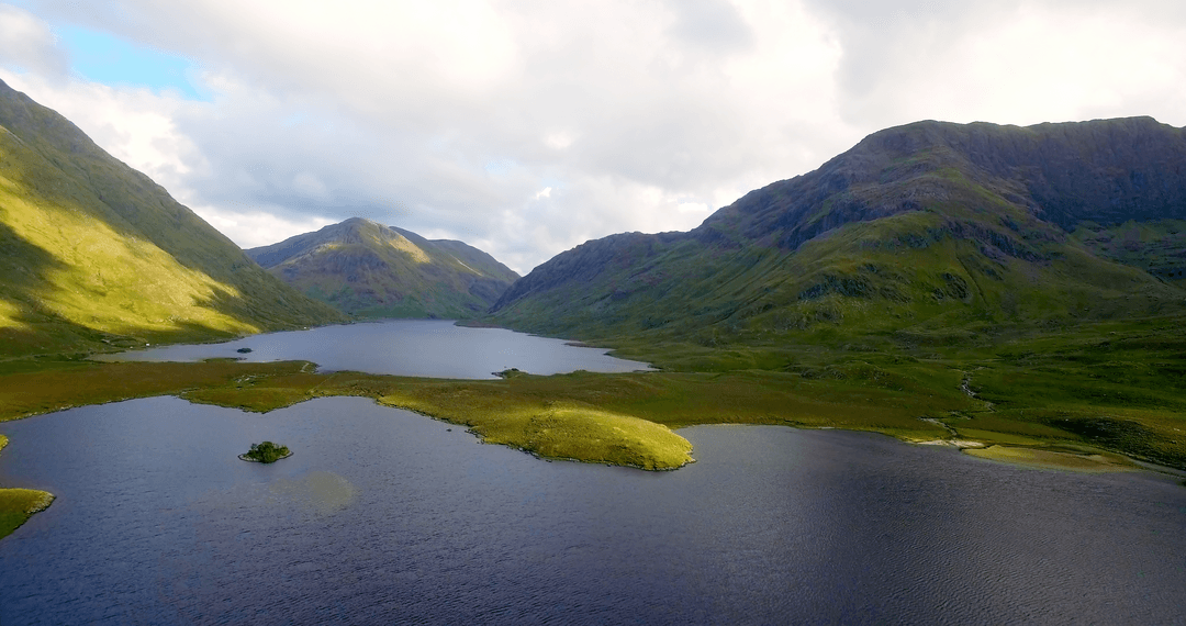 Tranquil Mountains and Lake Under Cloudy Sky in Transparent Landscape