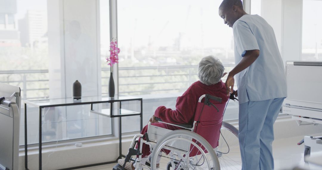 Caring Nurse Assisting Elderly Patient in Wheelchair at Modern Healthcare Facility - Free Images, Stock Photos and Pictures on Pikwizard.com