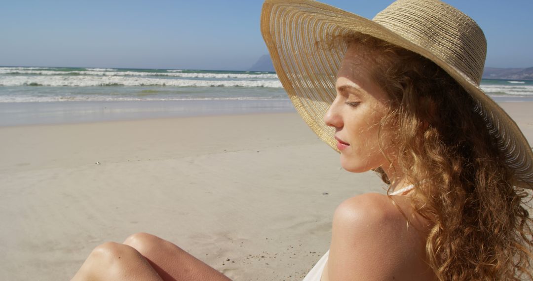 Young Woman Relaxing on Beach in Sun Hat - Free Images, Stock Photos and Pictures on Pikwizard.com