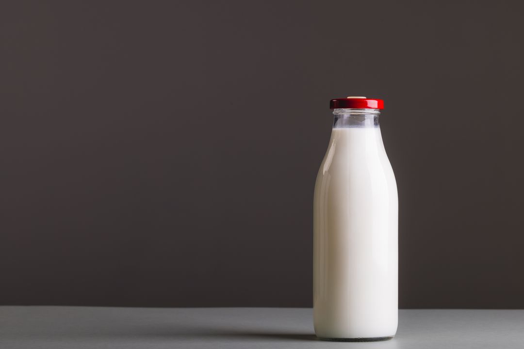 Close-up of milk bottle against gray background with copy space - Free Images, Stock Photos and Pictures on Pikwizard.com