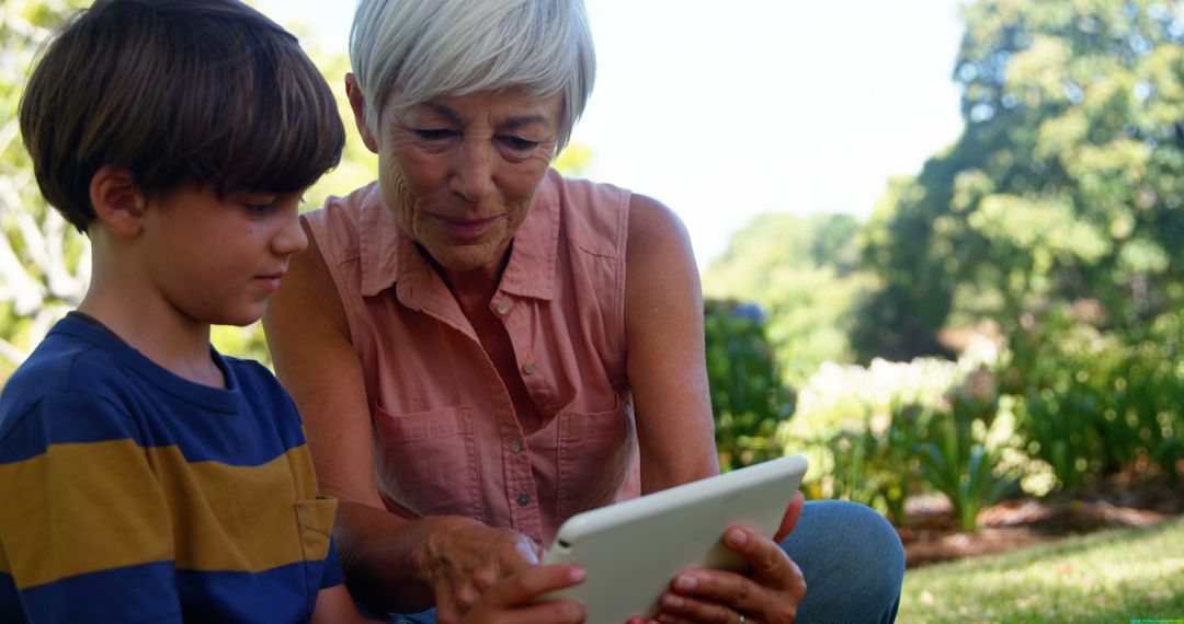 Grandmother and Grandson Sharing Digital Tablet Outdoors - Free Images, Stock Photos and Pictures on Pikwizard.com