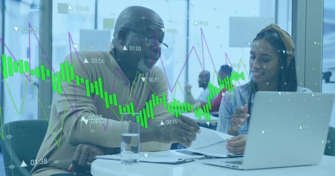 Senior Consultant Collaborating with Young Professional Overlapping Stock Charts