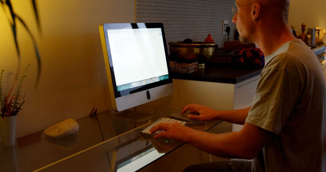 Focused Man Using Desktop Computer at Home Office Desk
