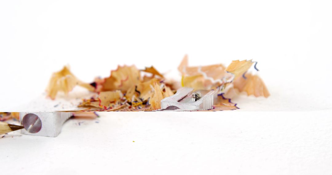 Pencil Shavings and Metal Sharpener on White Surface - Free Images, Stock Photos and Pictures on Pikwizard.com