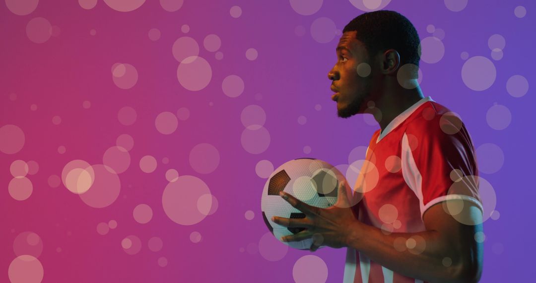 Focused Soccer Player Holding Ball with Bokeh Background