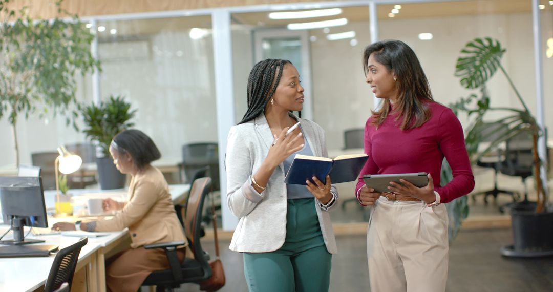 Black and South Asian Coworkers Collaborating While Walking in Modern Open-Plan Office