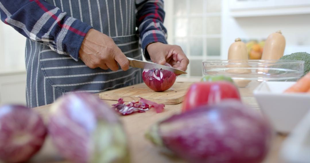 Man Cutting Red Onion On Wooden Board In Kitchen - Free Images, Stock Photos and Pictures on Pikwizard.com