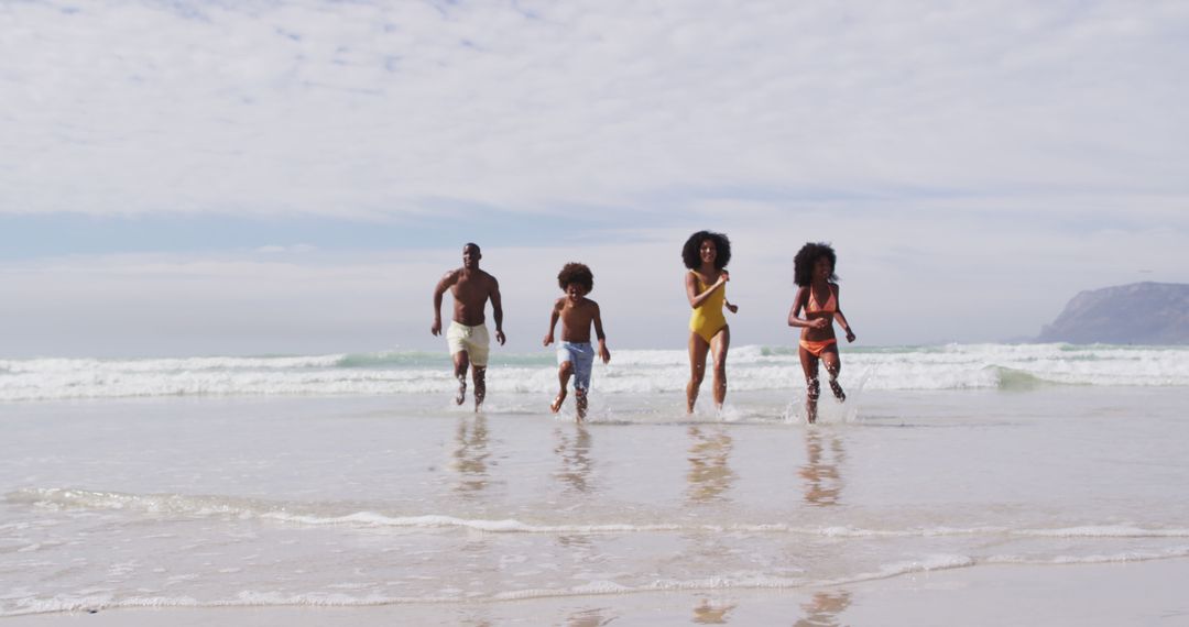 African american parents and two children running at the beach - Free Images, Stock Photos and Pictures on Pikwizard.com