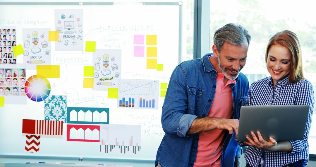 Executives Collaborating Over Laptop in Modern Office