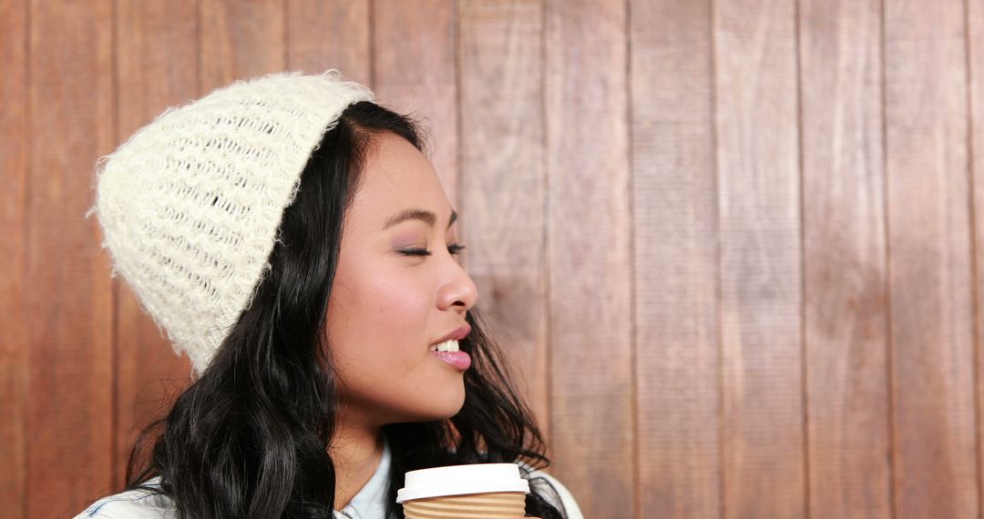 Young Woman Smiling with Coffee Against Wooden Wall - Free Images, Stock Photos and Pictures on Pikwizard.com