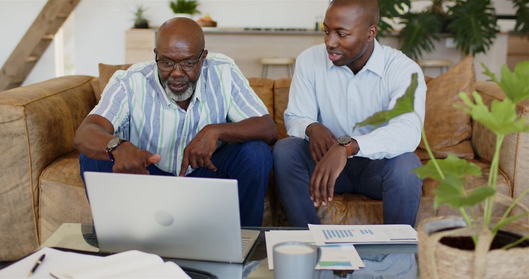 Business Meeting Between Clients Using Laptop for Project Discussion