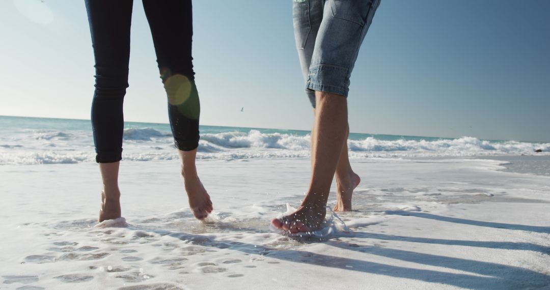 Couple Walking Barefoot on Beach Shore At Sunset - Free Images, Stock Photos and Pictures on Pikwizard.com