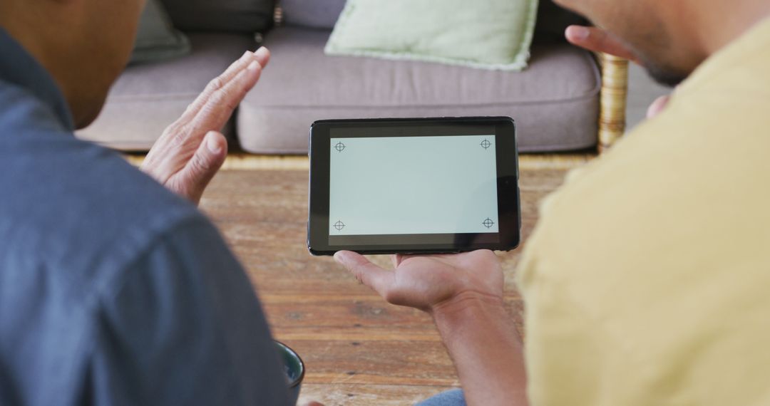 Two People Discussing over Tablet with Blank Screen in Living Room - Free Images, Stock Photos and Pictures on Pikwizard.com