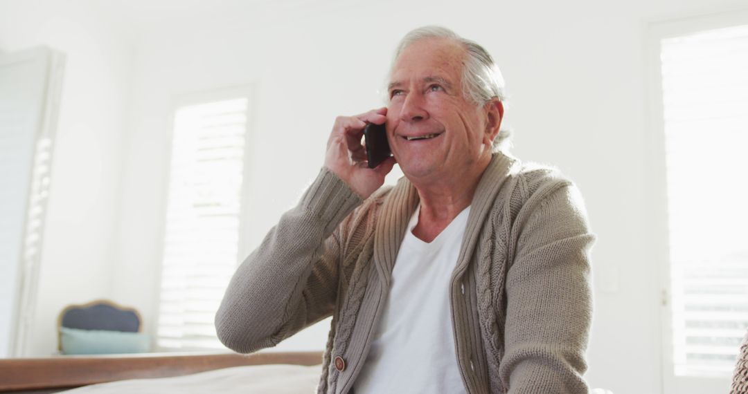 Senior Man Smiling While Using Smartphone at Home - Free Images, Stock Photos and Pictures on Pikwizard.com