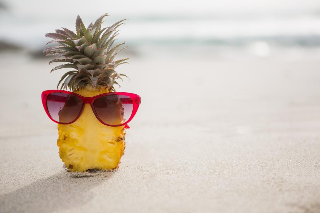 Halved pineapple and a sunglass kept on the sand - Free Images, Stock Photos and Pictures on Pikwizard.com