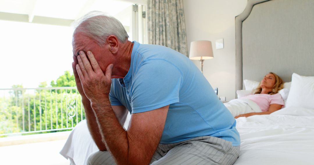 Senior Man Sitting on Bed with Ill Wife Resting - Free Images, Stock Photos and Pictures on Pikwizard.com