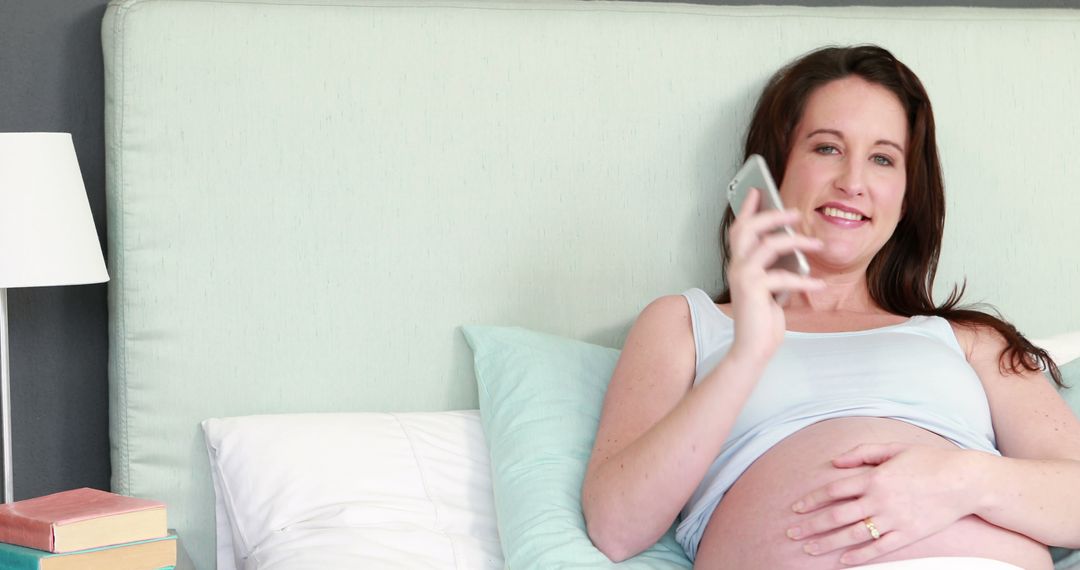 Pregnant Woman Talking on Phone in Comfortable Bedroom - Free Images, Stock Photos and Pictures on Pikwizard.com