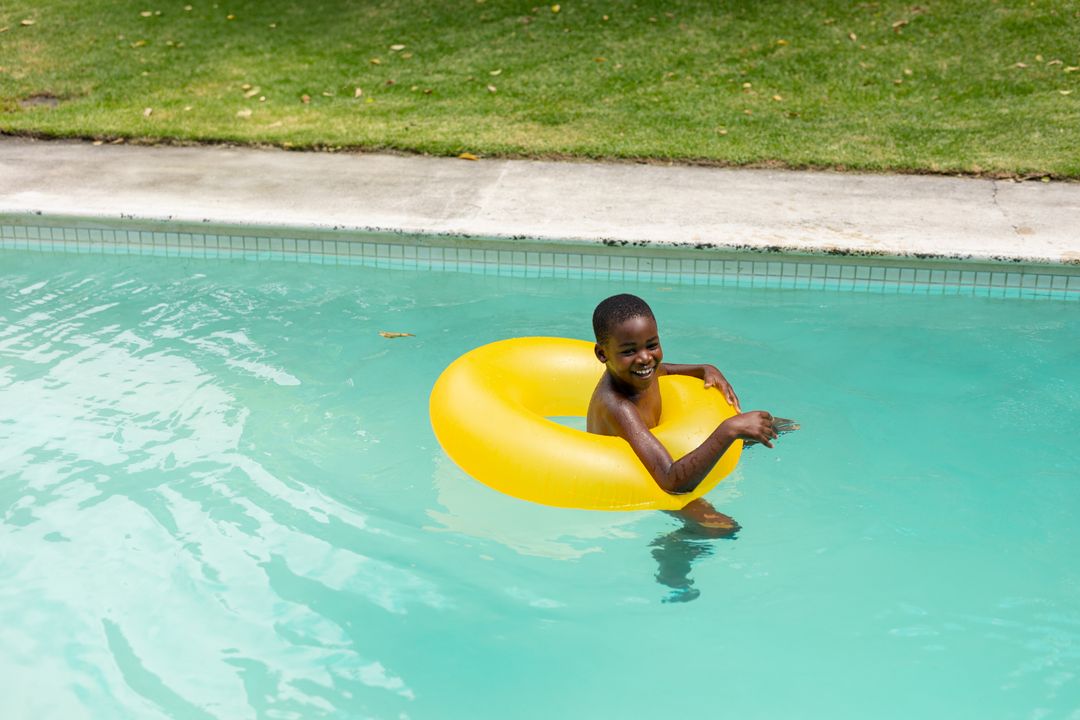 Joyful Boy Playing in Pool with Yellow Inflatable Ring