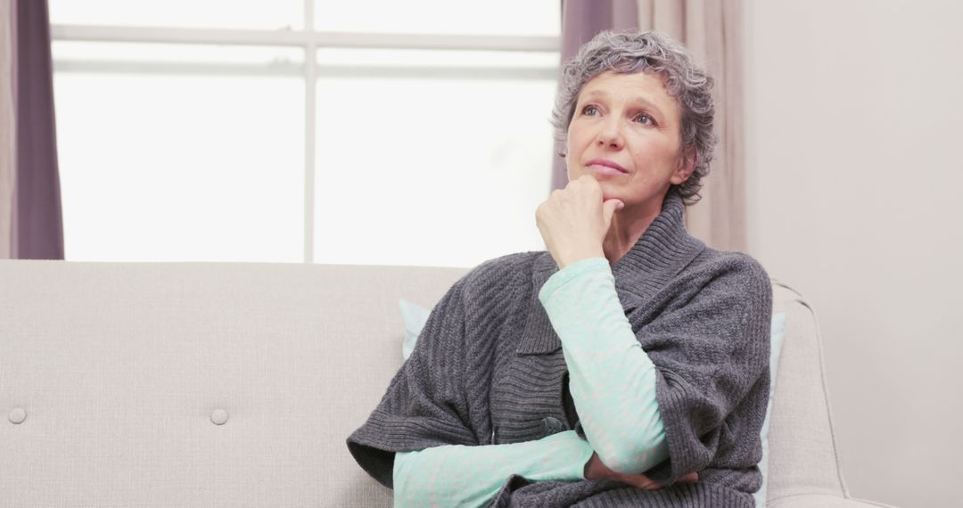 Thoughtful Older Woman Relaxing on Couch in Living Room - Free Images, Stock Photos and Pictures on Pikwizard.com