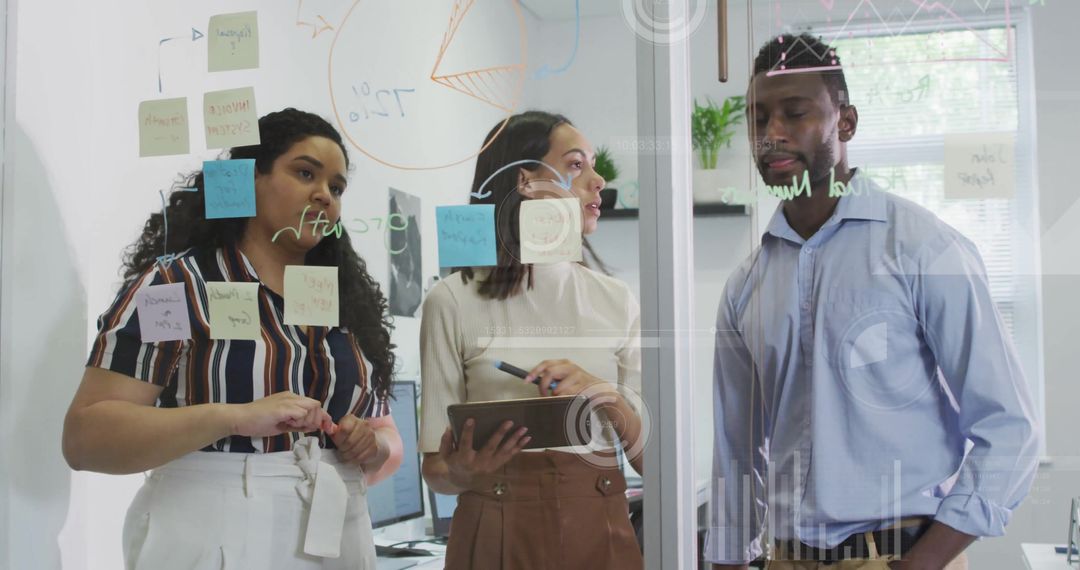 Diverse Team Discussing Strategy and Analyzing Data Overlaid with Digital Graphics