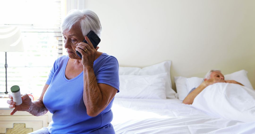 Elderly Woman Consulting Over Phone Holding Medication in Bedroom - Free Images, Stock Photos and Pictures on Pikwizard.com