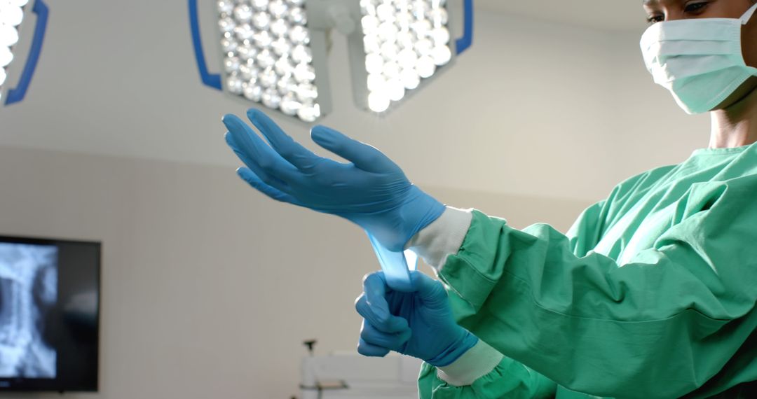 Surgeon Preparing for Surgery by Putting on Sterile Gloves in Operating Room - Free Images, Stock Photos and Pictures on Pikwizard.com