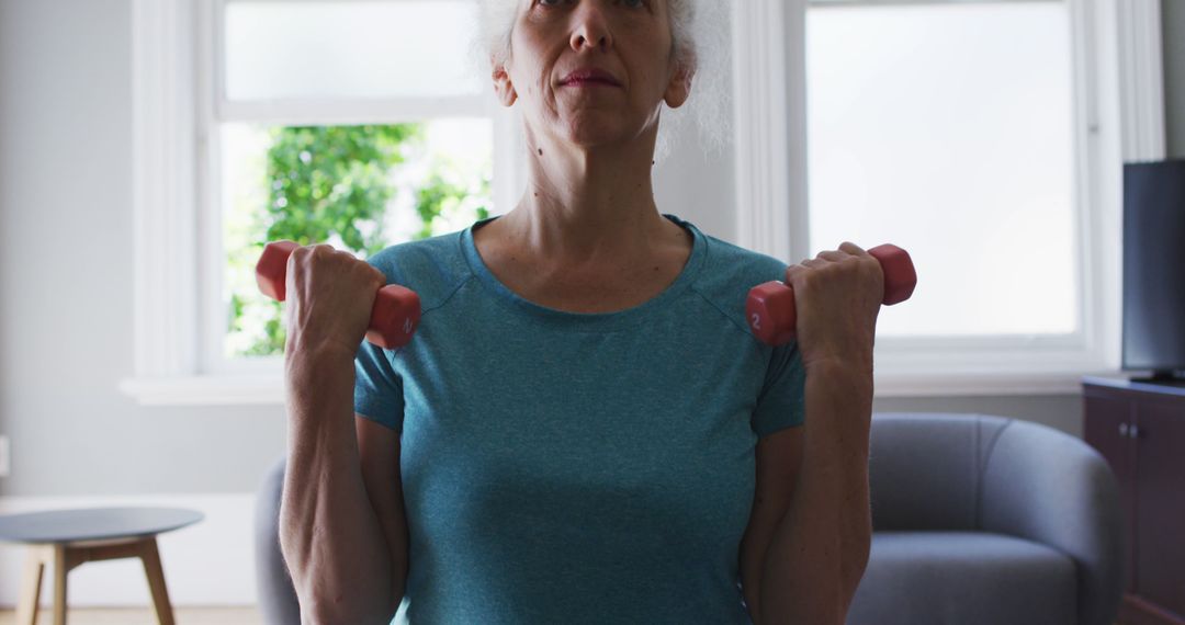 Senior Woman Exercising with Dumbbells at Home - Free Images, Stock Photos and Pictures on Pikwizard.com