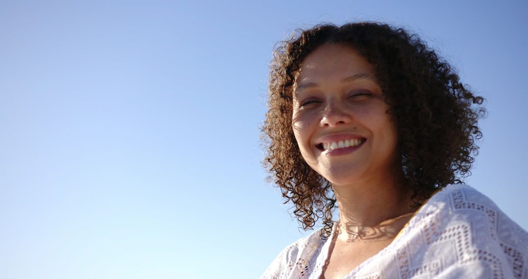 Smiling Woman Outdoors on Sunny Day with Clear Sky