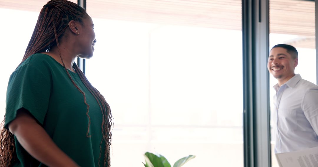 Colleagues Engaged in Productive Office Discussion by Window