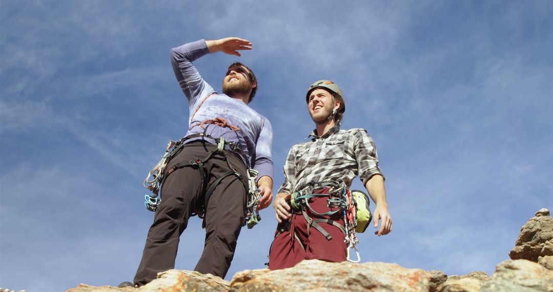 Two Rock Climbers Preparing for Ascent with Safety Gear on Sunny Day - Free Images, Stock Photos and Pictures on Pikwizard.com