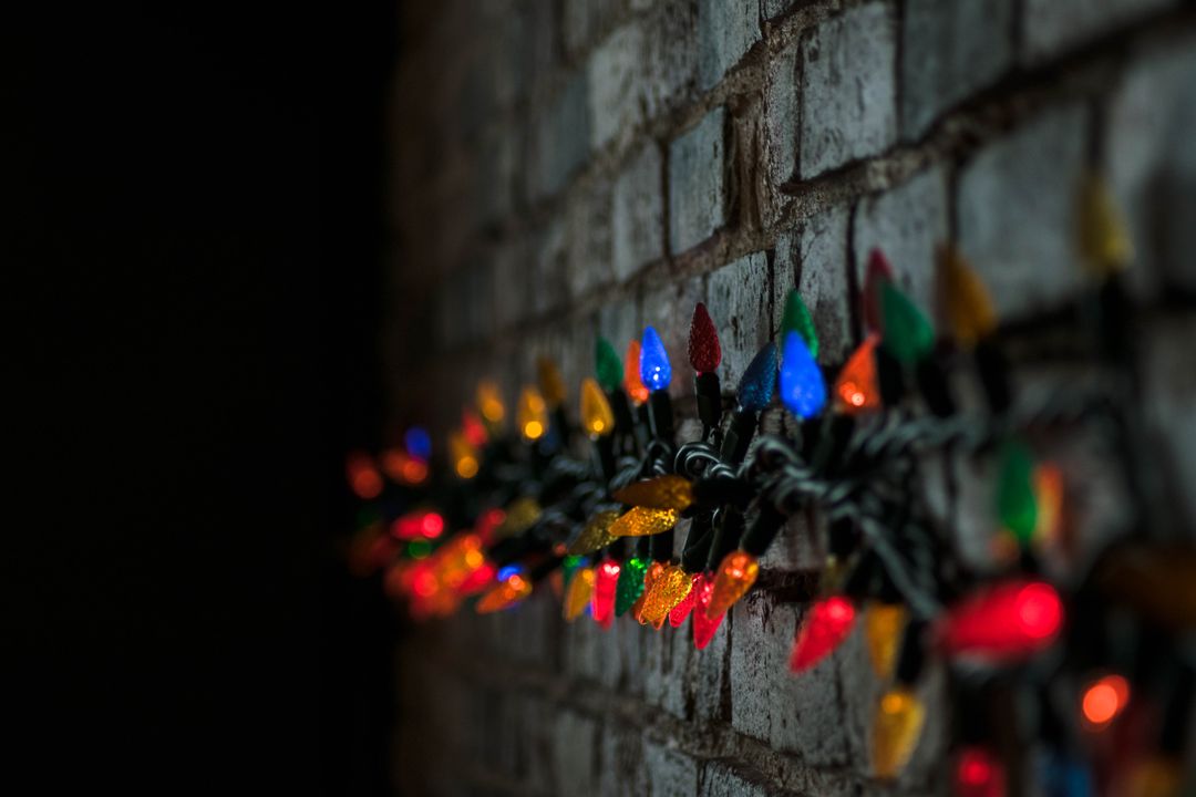 Colorful Fairy Lights on Brick Wall Celebrating Festivity - Free Images, Stock Photos and Pictures on Pikwizard.com