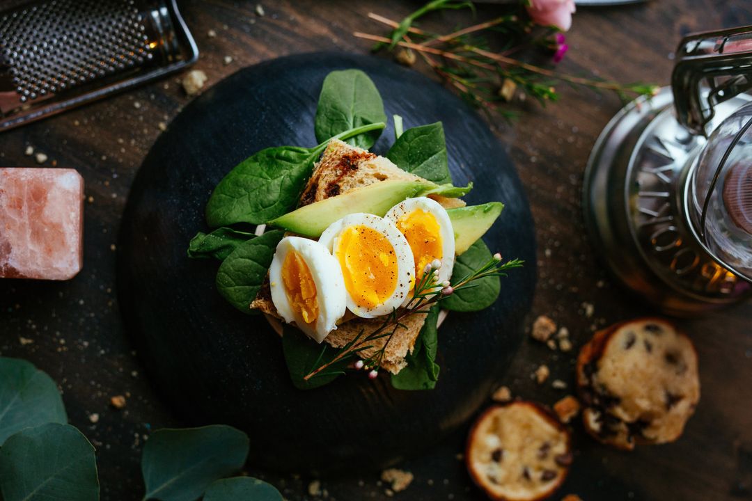 Gourmet Avocado Toast with Soft-Boiled Eggs on Rustic Whole-Grain Bread and Spinach