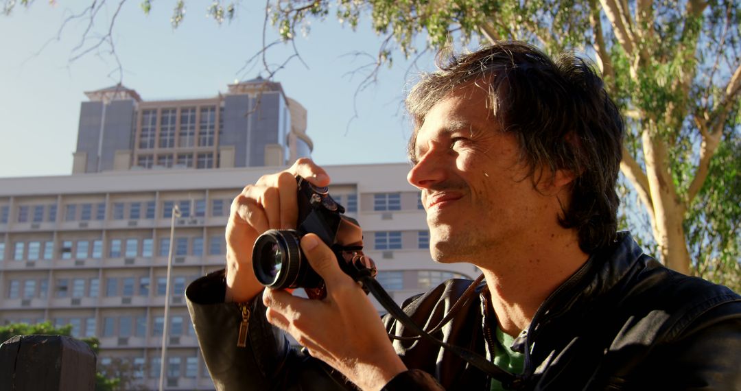 Smiling Photographer Capturing Outdoor Urban Scene in Daylight - Free Images, Stock Photos and Pictures on Pikwizard.com