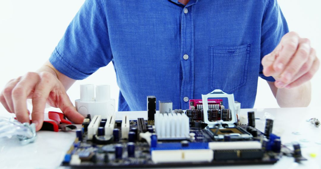 Technician Repairing Hardware at a Desk in Blue Shirt - Free Images, Stock Photos and Pictures on Pikwizard.com