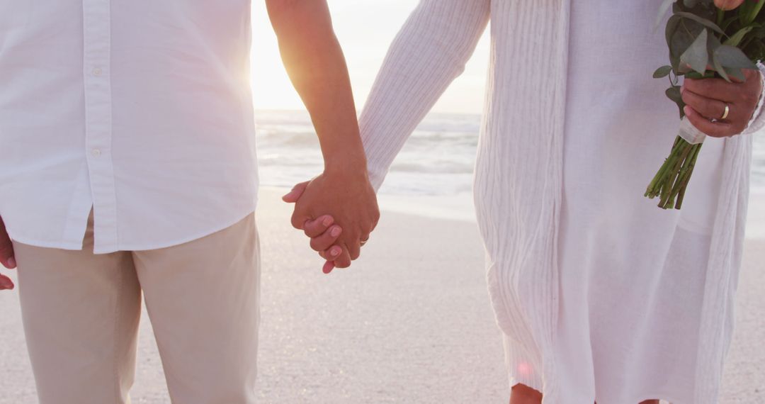 Senior Couple Holding Hands at Beach Sunset Celebrating Love