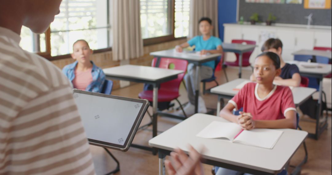 Teacher Presenting Lesson with Tablet to Engaged Middle School Students in Classroom