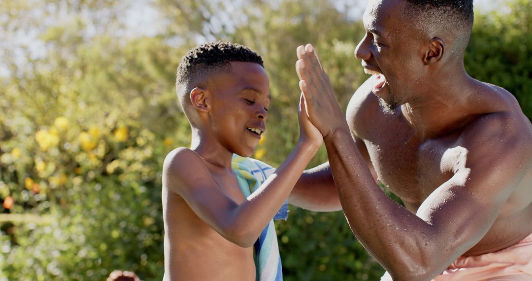 Father Helping Son Dry Off by Poolside
