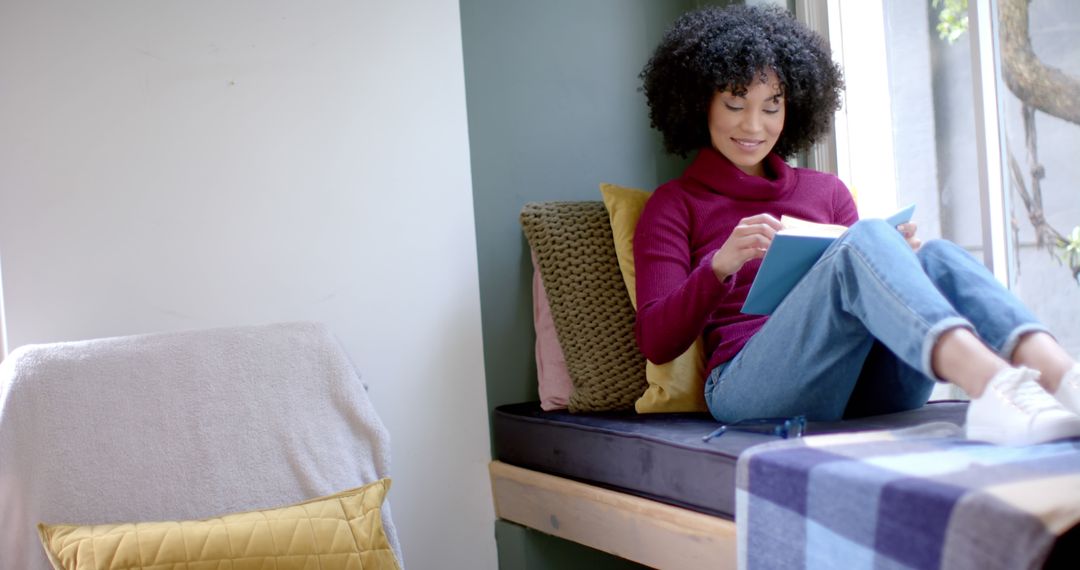 Woman Reading Book by Window with Relaxed Atmosphere - Free Images, Stock Photos and Pictures on Pikwizard.com